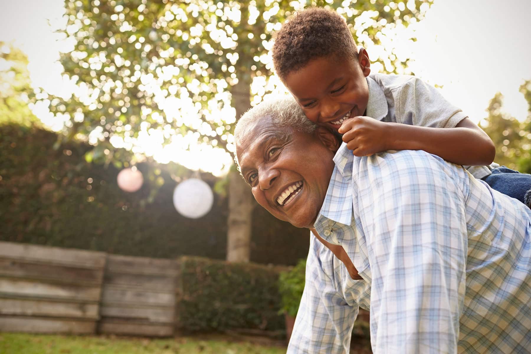 Young boy climbing on his grandfather's back