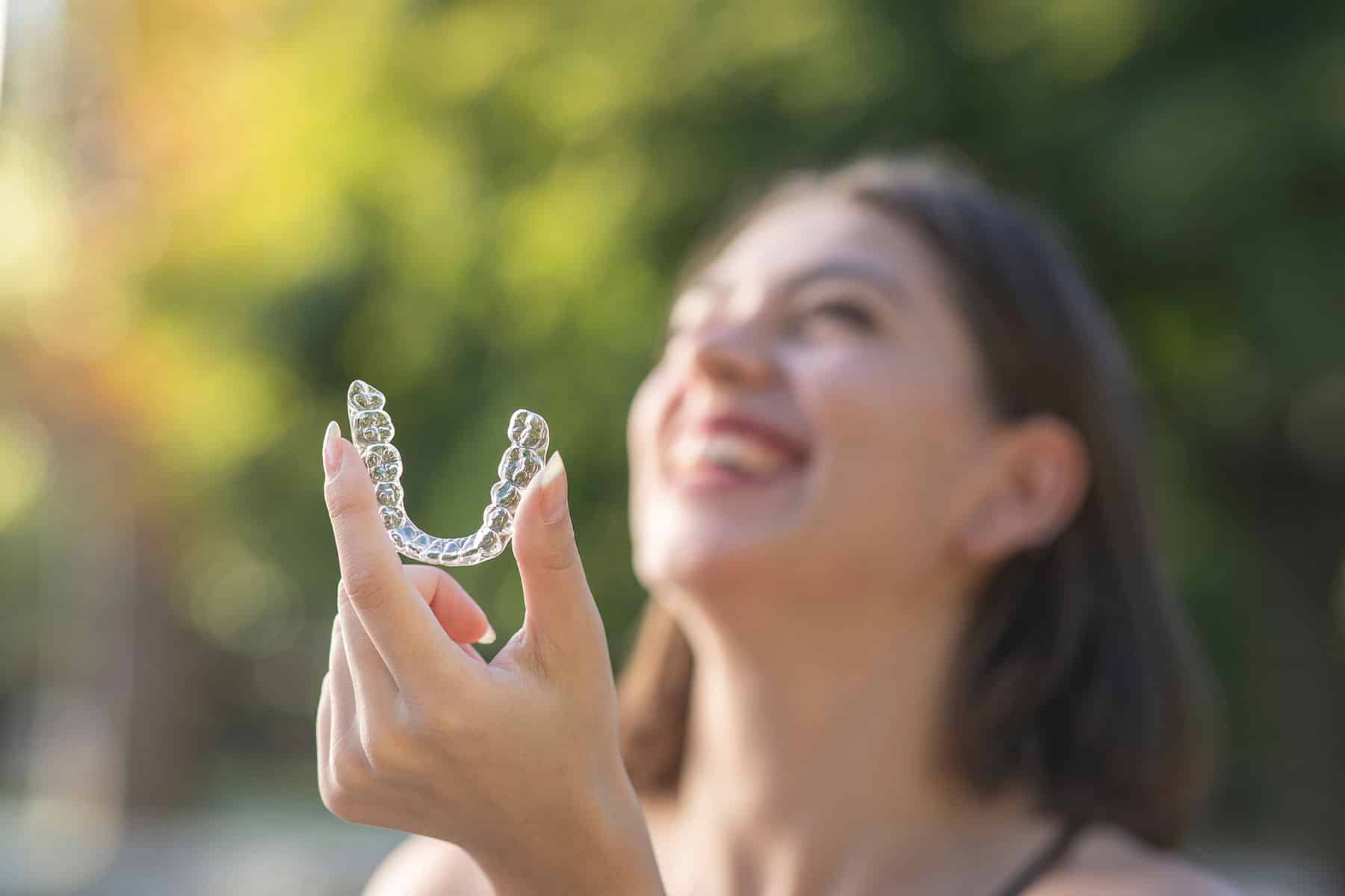 Woman holding invisalign braces