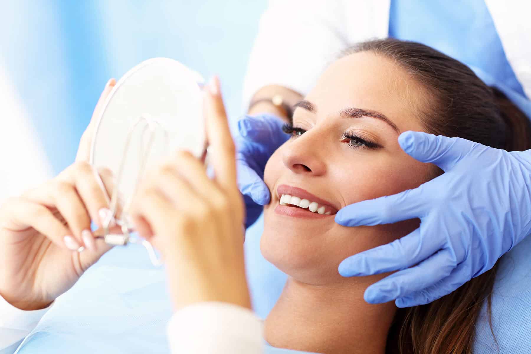 Woman admiring her teeth in a mirror